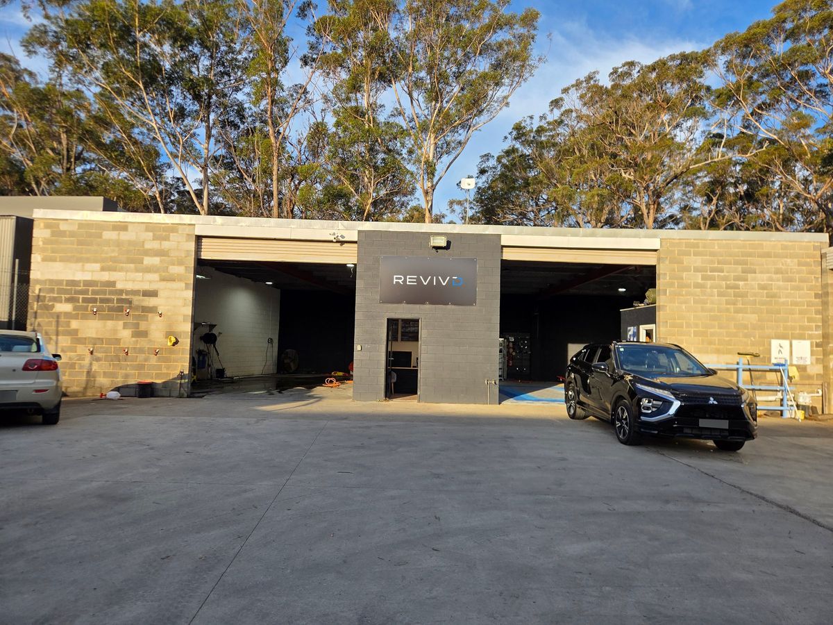 REVIVD studio frontage at Unit 2/5 McPherson Cct, Pambula NSW, with the charcoal REVIVD sign above the door